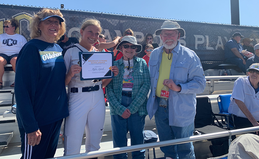 Dr. Gerry Pinkston, Pitcher Kylee Lynch, donors Leah and Larry Westmoreland in the bleachers during a softball game