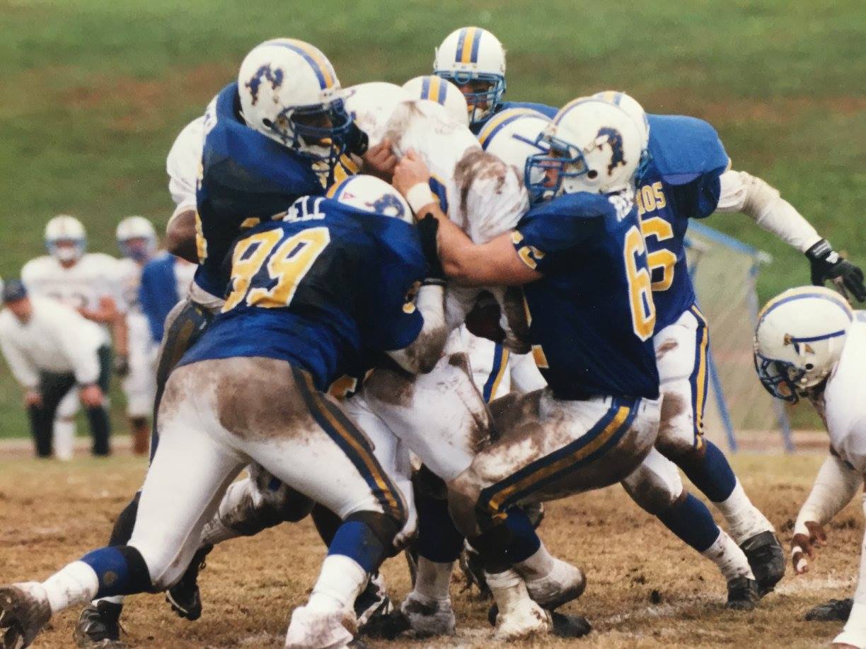 Photo of football players tackling one another during 1998 football game